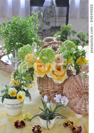 Basket and table with green and yellow flowers Basket and table with green and yellow flowers 64649988