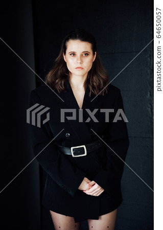Portrait of a beautiful fashionable brunette woman in a black business suit Portrait of a beautiful fashionable brunette woman in a black business suit 64650057