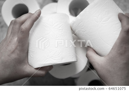 Female hand grabs a roll of toilet paper. Female hand grabs a roll of toilet paper. 64651075