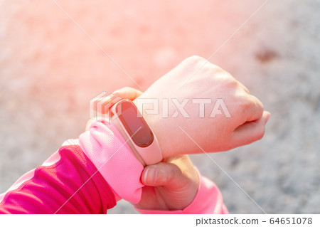 CLose up of sporty woman using fitness tracker on CLose up of sporty woman using fitness tracker on 64651078