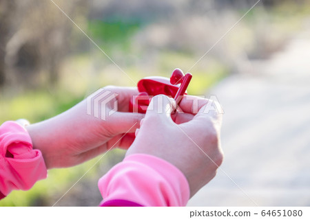 Girl takes out wireless headphones from a case for Girl takes out wireless headphones from a case for 64651080