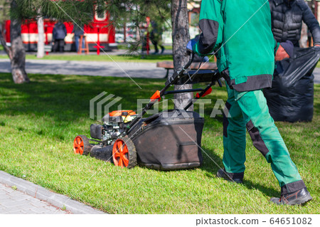 A man moves with an electrician to a lawnmower and A man moves with an electrician to a lawnmower and 64651082
