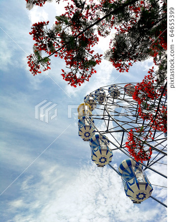 Ferris wheel on the background over blue sky 64655399