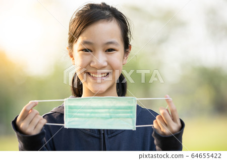 Asian child girl show a medical protective mask,campaigning to wear a mask before leaving the house to prevent the infection of the Coronavirus epidemic or outbreak of Covid-19,flu,contagious disease Asian child girl show a medical protective mask,campaigning to wear a mask before leaving the house to prevent the infection of the Coronavirus epidemic or outbreak of Covid-19,flu,contagious disease 64655422