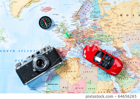 Model of red car, vintage camera and compass lie on Map of Europe Model of red car, vintage camera and compass lie on Map of Europe 64656265