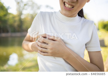 Asian child girl touching her breasts sore with severe pain in her chest,teenage girl feel menstrual breast pain,hormonal or growth in to adolescents cause irritation,painful engorgement to the breast 64656885