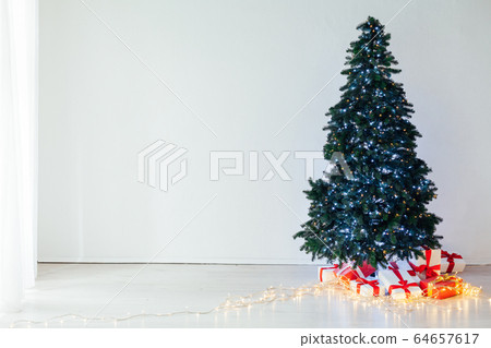 Christmas tree garland lights with new year holiday gifts December interior 64657617