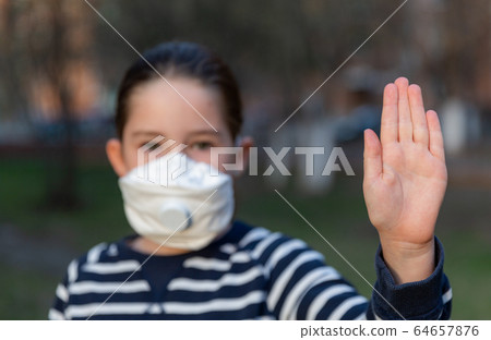 A girl wearing mask shows stop hands gesture for stop corona virus outbreak A girl wearing mask shows stop hands gesture for stop corona virus outbreak 64657876