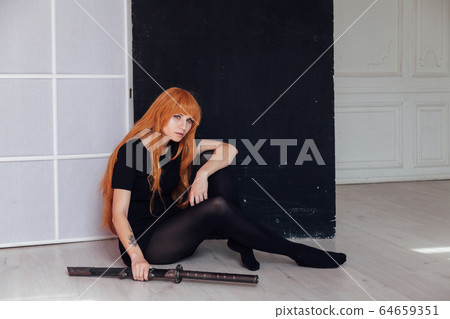 red-haired girl with a Japanese sword cosplayer anime Japan red-haired girl with a Japanese sword cosplayer anime Japan 64659351