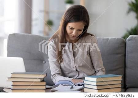 Smart student preparing for test exam reading textbook at home Smart student preparing for test exam reading textbook at home 64659632