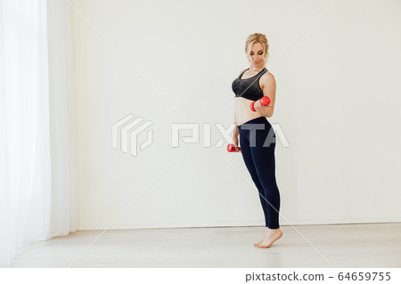 Beautiful blonde sports with dumbbells in fitness hall Beautiful blonde sports with dumbbells in fitness hall 64659755