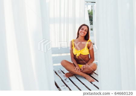 tanned woman in yellow swimsuit white tent tanned woman in yellow swimsuit white tent 64660120