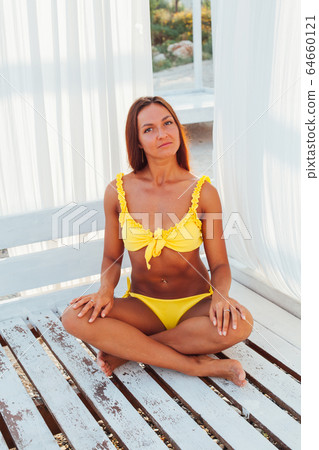 tanned woman in yellow swimsuit white tent tanned woman in yellow swimsuit white tent 64660121