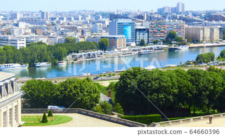 Paris, France - August 26, 2019: Paris from above showcasing the capital city's rooftops, the Eiffel Tower, Paris tree-lined avenues with their haussmannian buildings and Montparnasse tower. 16th 64660396