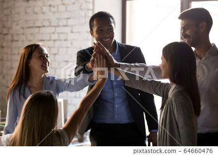 Excited multiracial team give high five, teambuilding concept 64660476