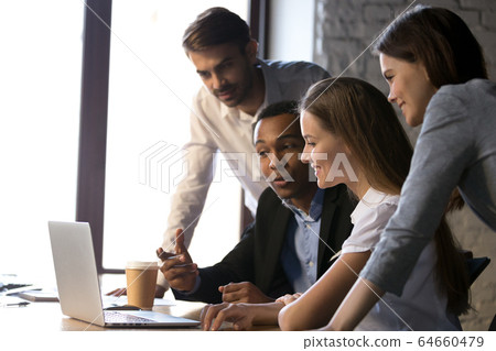 Smiling diverse team using laptop discussing online project at m 64660479