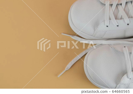 Pair of white shoes on pastel background. Trendy summer color. Copy space. Pair of white shoes on pastel background. Trendy summer color. Copy space. 64660565