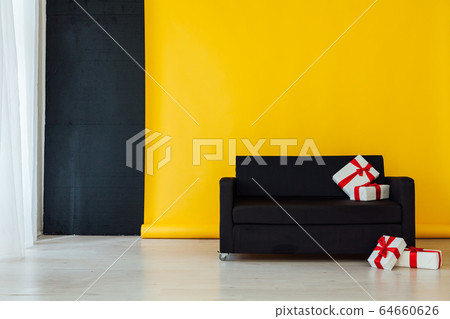 black sofa with gifts in the interior of the room with a yellow background black sofa with gifts in the interior of the room with a yellow background 64660626