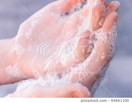 Soap foam on  child hands. Covid - 19 Coronavirus prevention. A child wash our hands with antibacterial soap. Coronavirus  pandemic protection by frequent hand washing. Selective focus 64661100