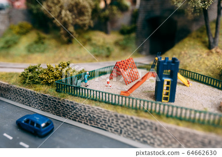 Miniature playground. Grandmother and grandson play in the playground Miniature playground. Grandmother and grandson play in the playground 64662630