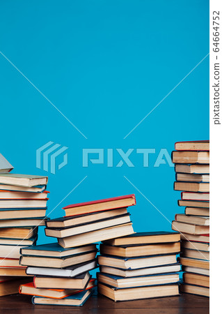 many stacks of educational books for learning preparation for college exams on a blue background 64664752