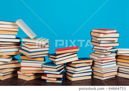 many stacks of educational books for learning preparation for college exams on a blue background 64664753