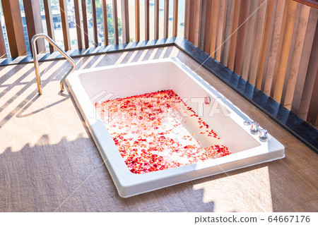 Red rose flower on water in bathtub decoration interior 64667176