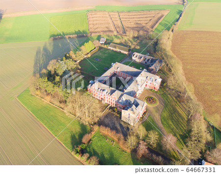 Aerial view of little farm castle surrounded by agriculture farmland et small forest 64667331