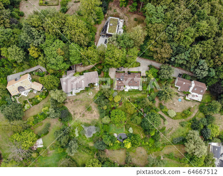 Aerial view of country side area with villas and garden surrounded by forest during green spring season 64667512