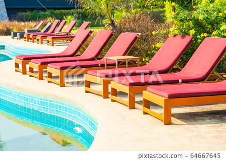 Beautiful empty chair around outdoor swimming pool in hotel resort Beautiful empty chair around outdoor swimming pool in hotel resort 64667645