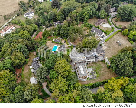 Aerial view of country side area with villas and garden surrounded by forest during green spring season 64667684