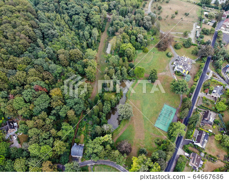 Aerial view of country side area with villas and garden surrounded by forest during green spring season Aerial view of country side area with villas and garden surrounded by forest during green spring season 64667686