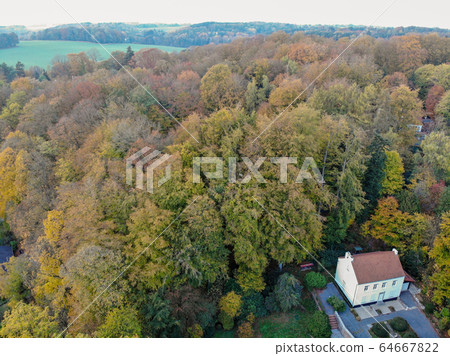 Aerial view of country side area with villas and garden surrounded by forest during green spring season 64667822
