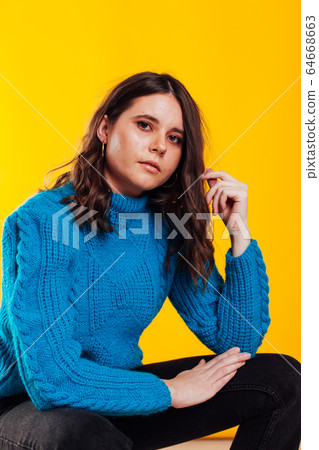 Portrait of a beautiful fashionable stylish woman in a sweater Portrait of a beautiful fashionable stylish woman in a sweater 64668663