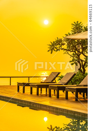 Beautiful sunrise around with umbrella and chair outdoor swimming pool 64669115