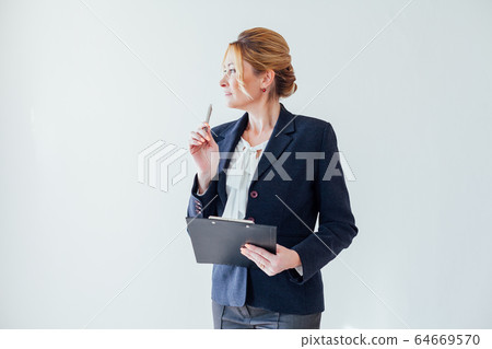 businesswoman in business suit with paperwork documents at work in the office businesswoman in business suit with paperwork documents at work in the office 64669570