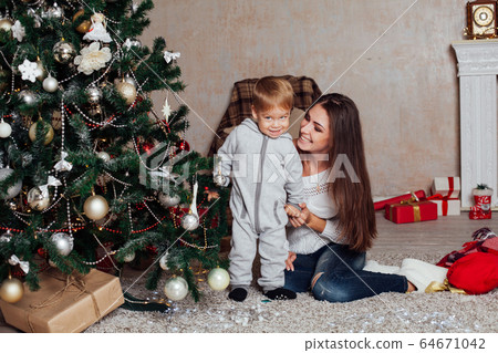 mother and little boy at Christmas tree with gifts 1 mother and little boy at Christmas tree with gifts 1 64671042