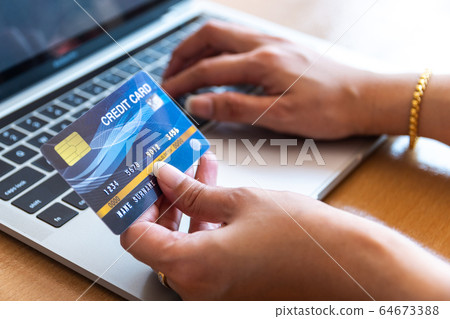 Woman holding credit card on laptop. On-line 64673388
