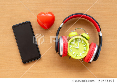 Headphones and alarm clock and smartphone and red Headphones and alarm clock and smartphone and red 64673391