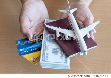 Man hands holding 100 dollar bills and airplane on Man hands holding 100 dollar bills and airplane on 64673414