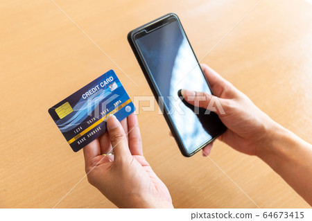 Woman holding credit card and smartphone. On-line Woman holding credit card and smartphone. On-line 64673415