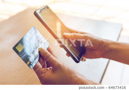 Woman holding credit card and smartphone. On-line Woman holding credit card and smartphone. On-line 64673416