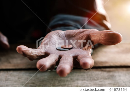 hand old man begging for money because of the hunger on the wood table. vintage tone hand old man begging for money because of the hunger on the wood table. vintage tone 64678564
