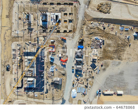 Aerial view of new construction site with crane and building materials.  64678868