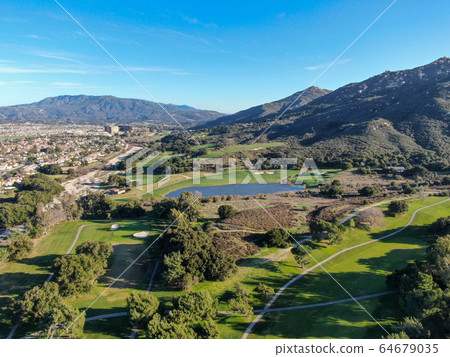 Aerial view of golf course with green field in the valley. 64679035