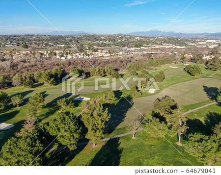 Aerial view of golf course with green field in the valley. Aerial view of golf course with green field in the valley. 64679041