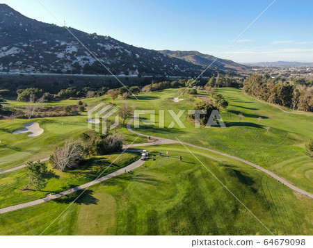 Aerial view of golf course with green field in the valley. 64679098