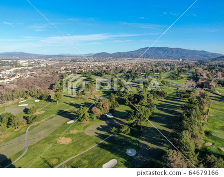 Aerial view of golf course with green field in the valley. Aerial view of golf course with green field in the valley. 64679166