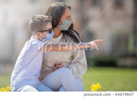 Early teenage boy points to the right when sitting Early teenage boy points to the right when sitting 64679607