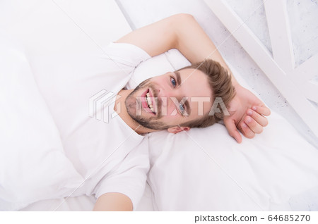 Handsome man relaxing in bed. Establish regular Handsome man relaxing in bed. Establish regular 64685270
